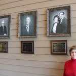 Diane Brandenberg Seales standing next to the canvas of her parents, Homer L. and Bessie (Walton) Brandenberg, the largest land owner in Siluria at one time. Mr. T.C. Thompson’s picture is in the middle; Thompson Schools were named after him, and he originally owned the Buck Creek Cotton Mills. On the left is Fred F. Phillips. Fred acquired the mill from his father, J.T. Phillips.